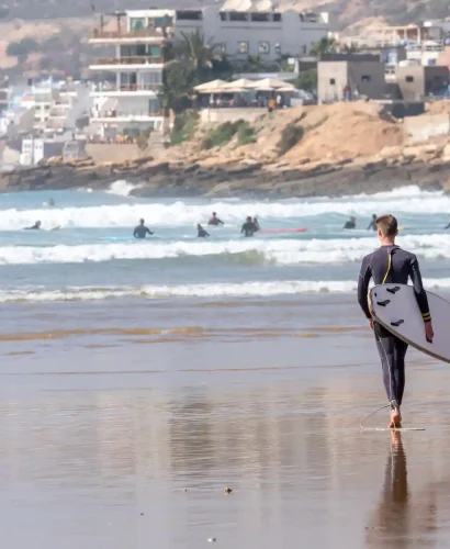 a guy surfing in Taghazout beach Agadir Coastal Morocco Tours