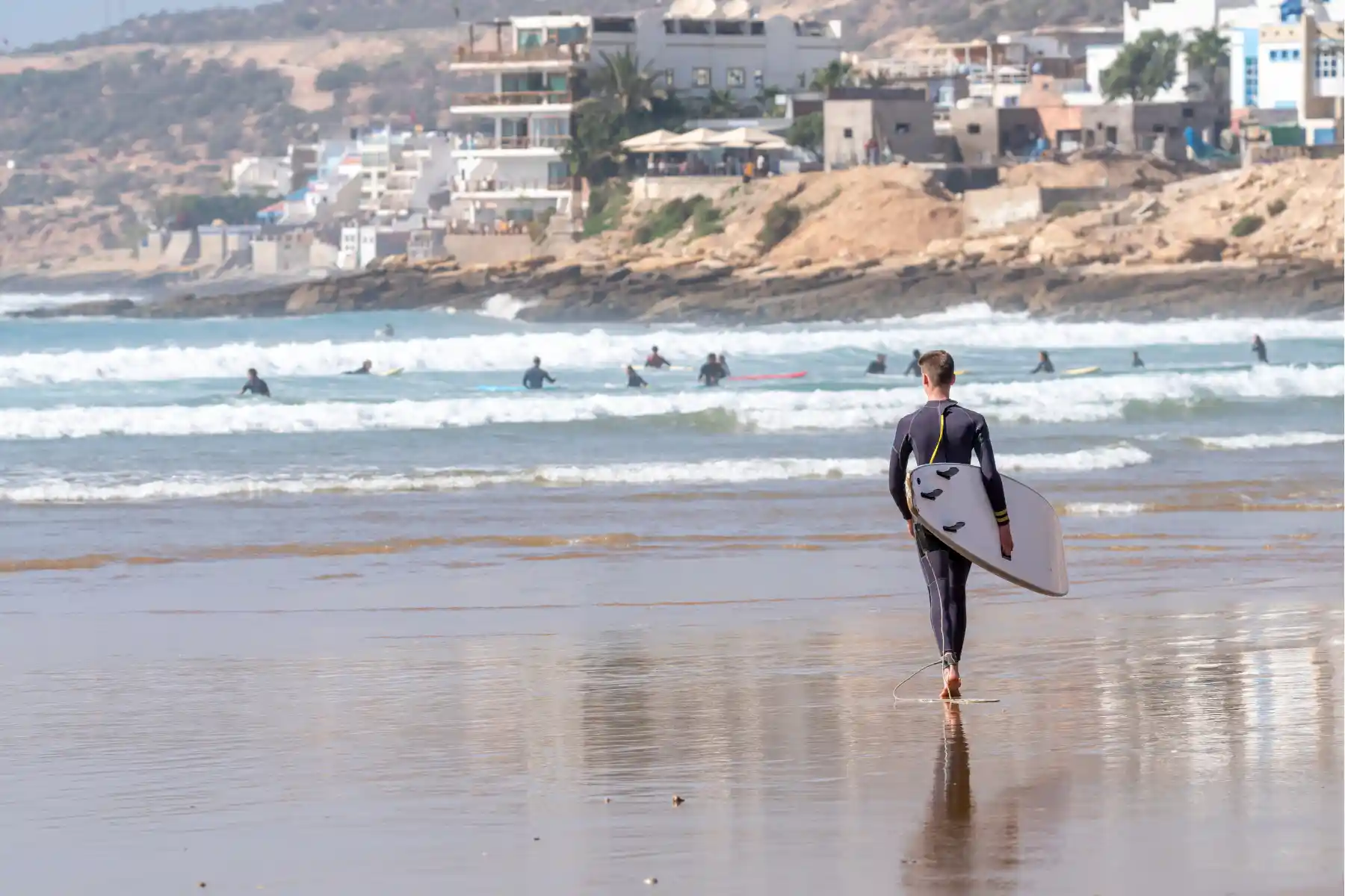a guy surfing in Taghazout beach Agadir Coastal Morocco Tours
